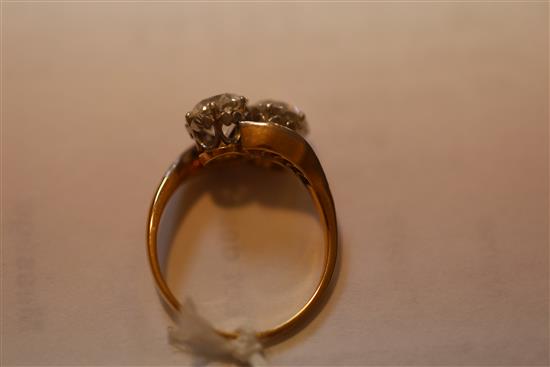 A gold and platinum, two stone diamond crossover ring with diamond set shoulders, size P.